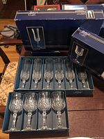 Six champagne glasses and four wine glasses arranged inside their original Cristal d’Arques boxes, showcasing the packaging and overall set condition.