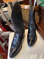 Front view showing the pointed toes and decorative stitching on vamp and shaft, black color western boots