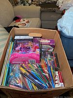 Box with colored pencils, Barbie doll, coloring books and games
