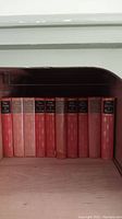 Shelf with red hardcover volumes labeled 'The Works of Shakespeare' and other classic authors.