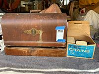 Front view of the vintage Singer sewing machine wooden case showing the model label and wear on the wood.