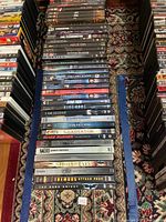 Photo of 43 DVDs mainly action, superhero, horror movies stacked on the floor showing titles like Saw, X-Men, Blade Runner.