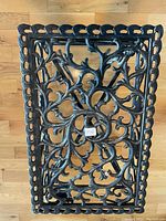 Top view showing detailed floral and vine cut-out pattern with scalloped edge and small sticker.