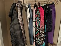 Photo showing a row of various women's clothing items hanging including coats, tops, skirts, and shirts in size 8-10