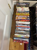 Photo showing top view of DVD stack with titles including Blue Crush, Premonition, Ned Kelly, Jackass The Movie, Bean, Adaptation, and more.