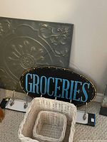 Metal wall art piece with embossed floral and ornamental design in a grayish metal finish