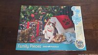 Top view of the puzzle box showing image of cats near Christmas tree and pet house with 'Merry Christmas' text.