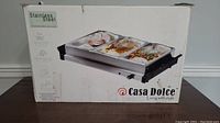 Photo of the boxed Casa Dolce stainless steel buffet server showing the product image and branding on the packaging.