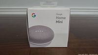 Front view of sealed Google Home Mini box in chalk gray color showing the product image and branding