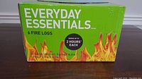 Green Everyday Essentials box containing 6 fire logs with burn time and weight details on front.