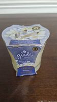 Glade candle in original packaging showing floral design, brand and fragrance details
