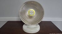 View of Presto HeatDish Plus Foot Light heater with yellow and white circular logo and metal grille front.