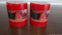 Two red strawberry kiwi candles labeled Fragrant Reflections showing front label with fruit image.