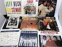 Front view of nine 45 RPM picture sleeves displayed including Jeff Beck & Rod Stewart, Saga, David Bowie & Mick Jagger, Joe Walsh, Burton Cummings, April Wine, and The Jeff Healey Band.