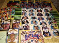 Photo showing multiple 1988 Hostess collectors edition card discs depicting Toronto Blue Jays and Montreal Expos players, along with 1994 Bat Rack bubble gum pack and sealed baseball card packages.