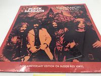 Front cover of the Black Sabbath The Paranoid Tour 1970 50th Anniversary Edition blood red vinyl record showing the band photo with a dark and red forest background.