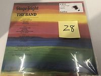 Back of sealed album showing track listing and credits on multicolor striped background.
