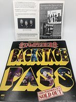 Front and inside view of The Stampeders 'Backstage Pass' gatefold album cover with large yellow and black lettering and cutout photos of the band.