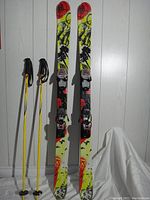 Top and side view of K2 Juvy twin tip skis with Marker bindings alongside Gabel ski poles, showing overall items included.
