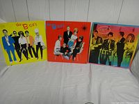 Front view of three vinyl records from The B-52s with colorful album covers.