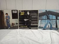 Photo showing three Billy Joel album covers: '52nd Street', 'An Innocent Man', and 'Glass Houses'. They are in good condition with visible shelf wear.