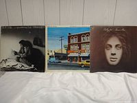 Three vinyl album covers facing front: The Stranger, Streetlife Serenade, Piano Man.