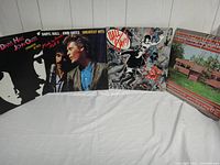 Four Daryl Hall & John Oates album covers arranged side by side on a white cloth background, showing front cover designs including photographic portraits and graphic artwork.