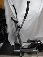 Full side view of elliptical machine showing frame, pedals and base