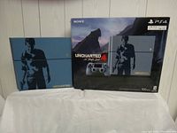 Photo showing the Uncharted 4 Limited Edition PS4 console alongside its original box with matching artwork and branding.