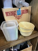 Various ceramic and plastic bowls including cream ceramic bowls and plastic container.