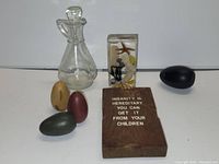 Photo showing four wooden eggs in different colors, the glass angel figurine, the display box containing sea-themed miniatures, and the wooden plaque with engraved quote.