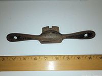 Top down view of Stanley Bat Wing Pull Plane on white background with ruler for scale, showing rusty cast iron and tool brand.