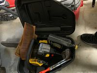 Photo of McCulloch Mac 3516 chainsaw inside hard plastic carrying case with manual and oil bottle.