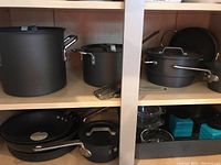 Overview of two shelves displaying cookware and Pyrex dishes