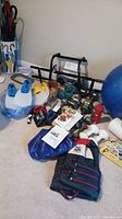 Wide view of lot showing assorted fitness equipment including dumbbells, exercise balls, jump ropes, life jacket, swimming flippers, and workout materials.
