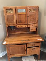 Full front view of oak cabinet showing upper hutch, lower work surface and storage.