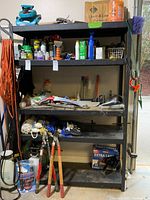 Full view of shelving unit showing all five shelves loaded with various items.