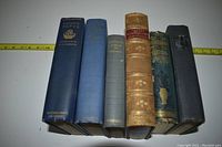 Seven volumes upright, showing spines from left: Everybody’s Pepys, Greenshields poem volume, Tennyson’s Poems, Scott’s Poems, Poets Royal (green), Laurentians (mountain scene), dark cloth volume