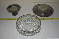 Photo showing the silver flower arranger with tarnished surface and the clear cut glass bowl with a silver rim.