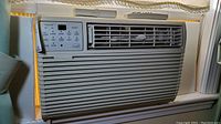 Front view of Kenmore model 253.75088301 window air conditioner installed in window with visible control panel and air vents.