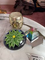The full set arranged on a marble surface including glass candle holder, paperweight, prism, and mirror coaster.