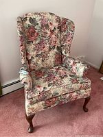 Front view of floral wingback armchair showing upholstery and seat cushion.