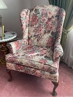 Front view of floral upholstered Broyhill wingback chair showing seat, arms, and legs
