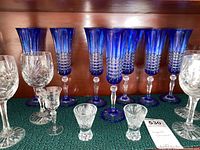 Photo showing cobalt blue cut-to-clear crystal stemware with clear cut bases, along with some clear crystal cordial glasses in front.