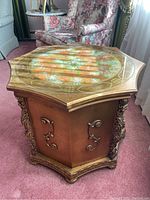 Hexagonal wooden end table with glass top and carved corner details shown from the top angle.