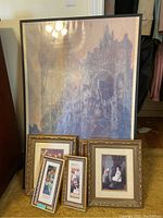 Large framed impressionist print with multiple smaller framed prints arranged in front, taken to show size and variety
