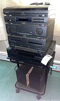 Stacked Magnavox FP9410 stereo components plus Sony 5-disc CD changer on top of rolling media stand with speakers below.