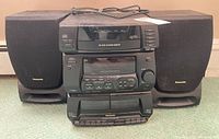 Full view of Panasonic stereo system with two speakers, power cord, and visible wear.