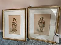 Both framed prints depicting children in traditional Japanese clothing, artist signatures visible, gold-tone wooden frames with white mats.
