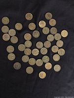 Image showing 36 Canadian tombac 5 cent coins scattered on a dark cloth background.